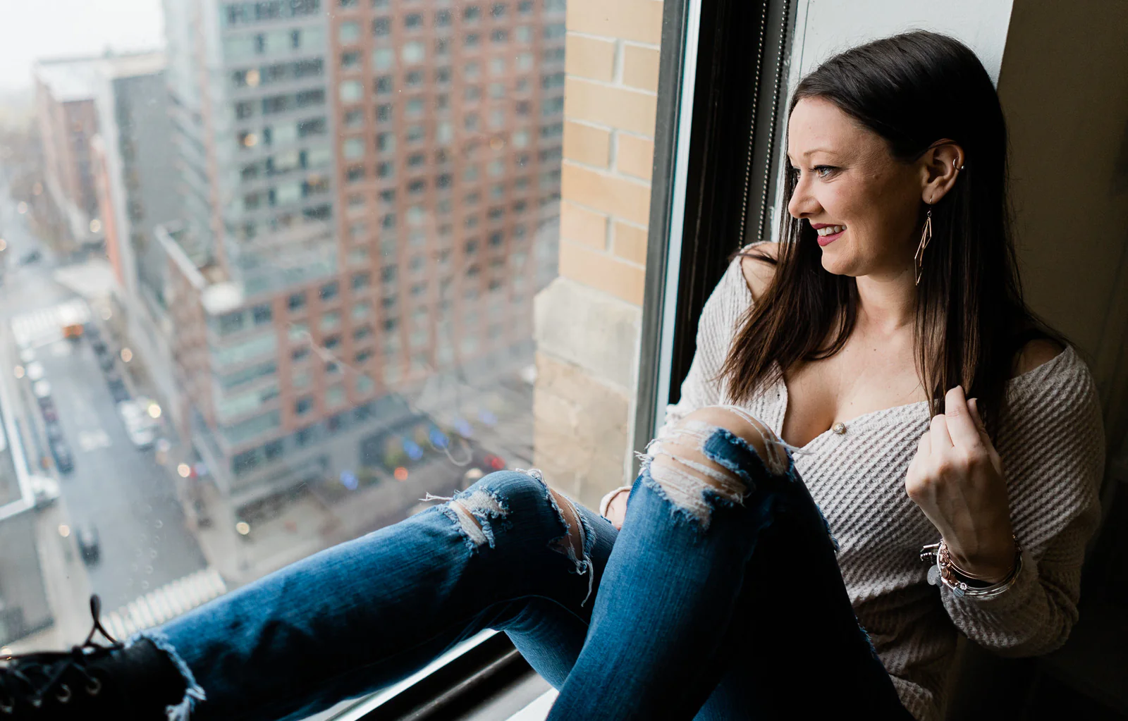 Portrait of a woman seated in a downtown high-rise window