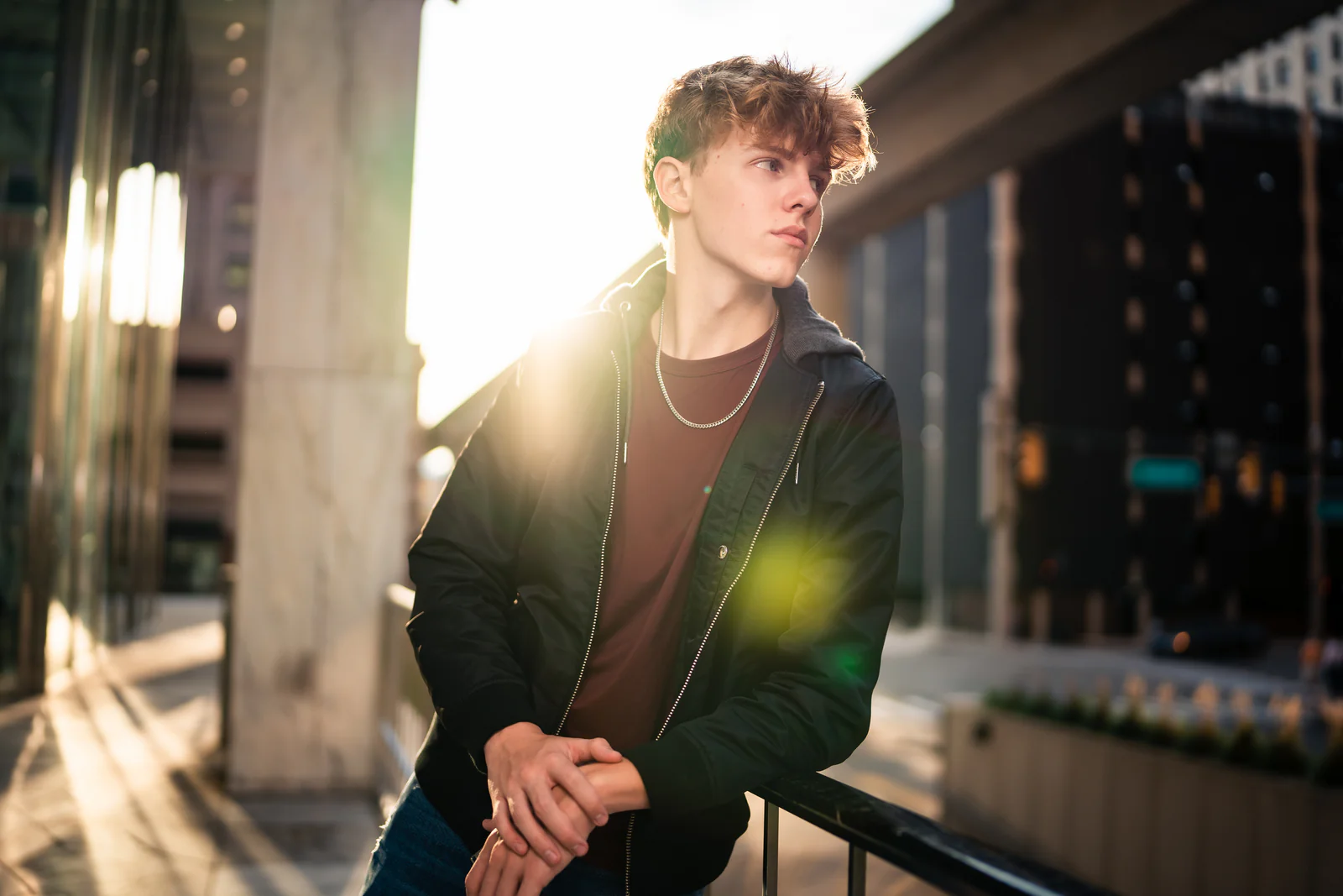 Senior portrait of a young man downtown at golden hour