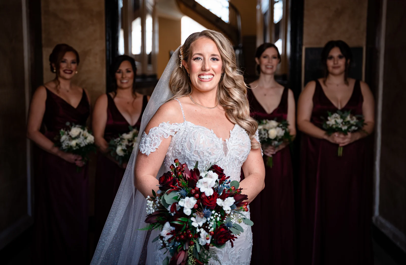 Bride with her bridesmaids in burgundy gowns